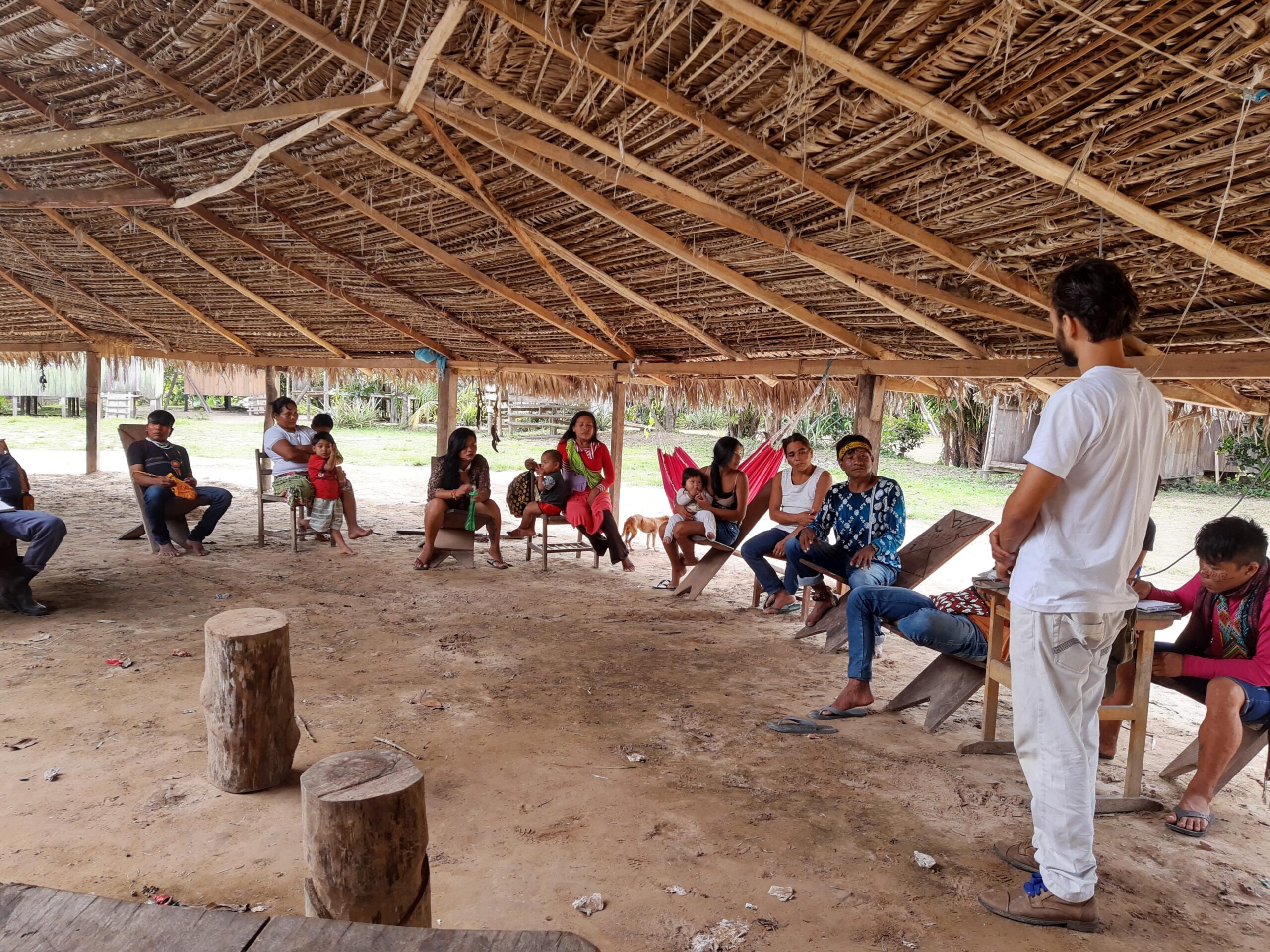 Reunião comunitária com explicações sobre projetos de desenvolvimento.